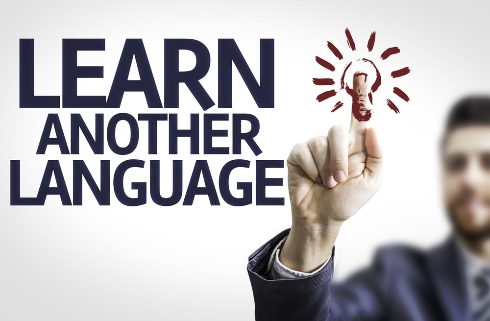 Business man pointing to transparent board with text Learn Another Language